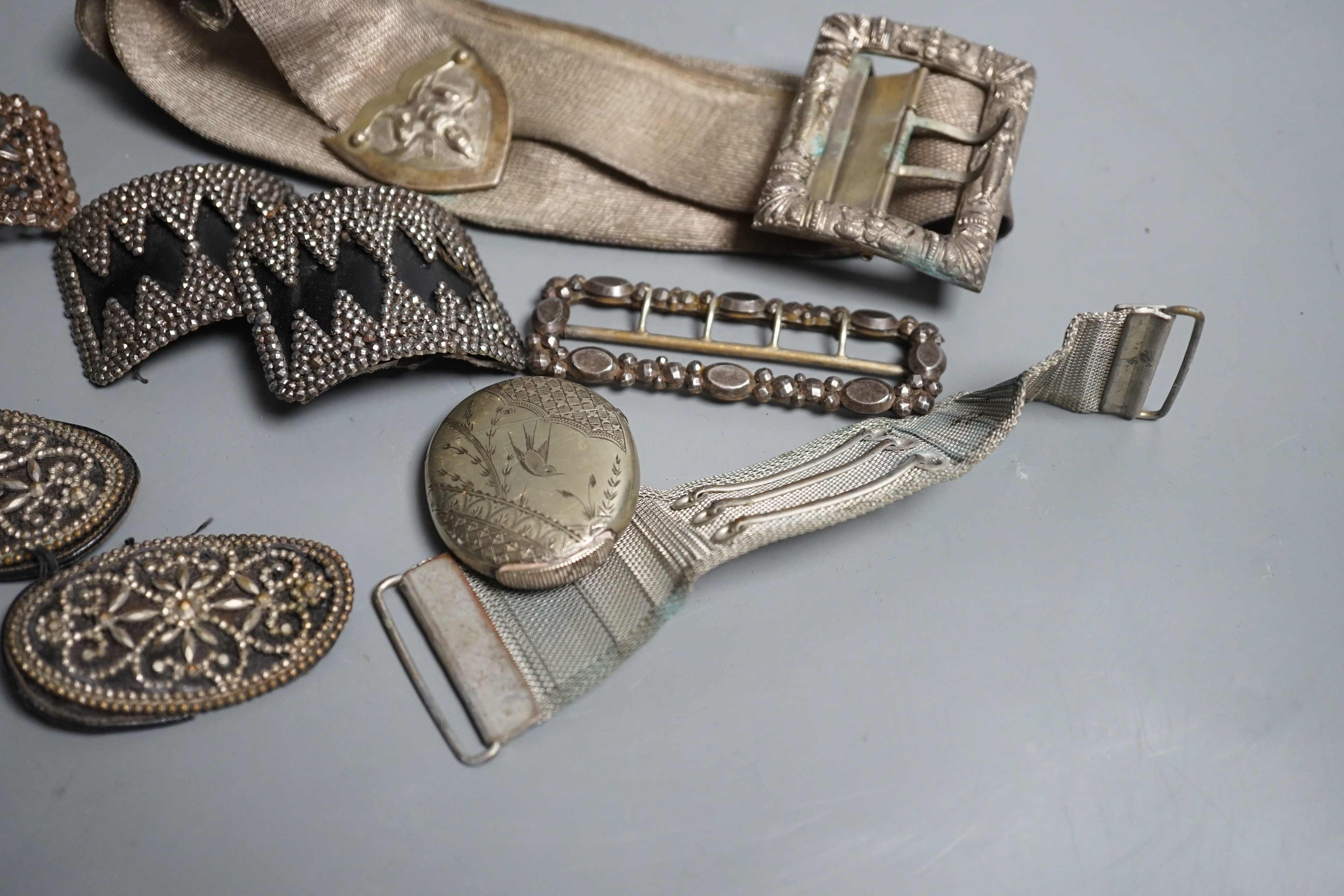 An Indian metal belt, four assorted metal shoe buckles and an aesthetic engraved silver plated vesta case.